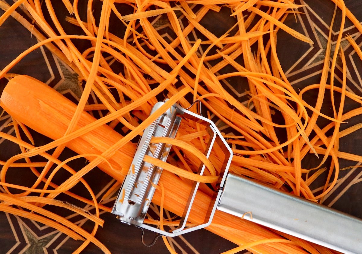Julienne peeler with carrots cut into julienne (thin long) slices.
