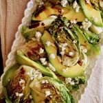 Little Gem Lettuce Salad with avocado slices on white plate.