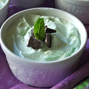 Individual Grasshopper Mousse Pies in pretty white ramekins with fresh mint leaves.