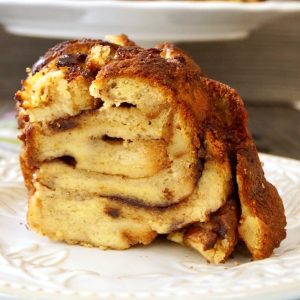 One large slice of French Toast Bread Pudding with cake plate behind.