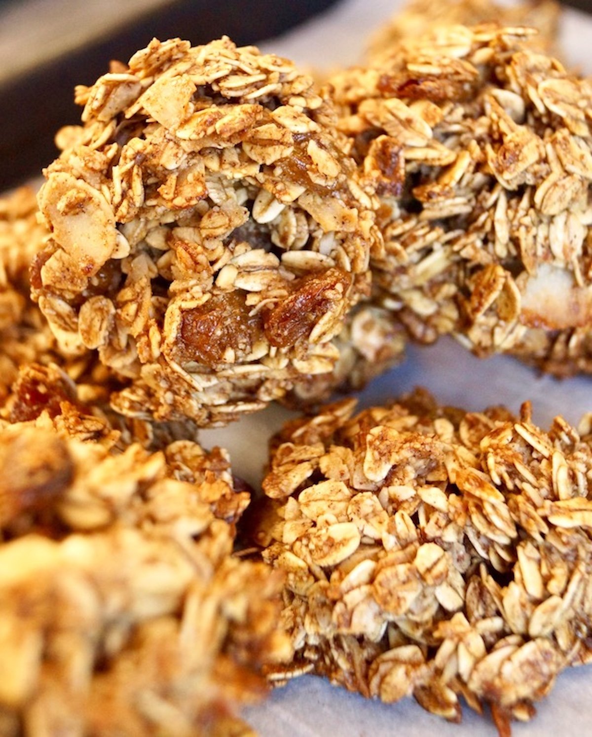 A few granola cookies with golden raisins on top of each other.