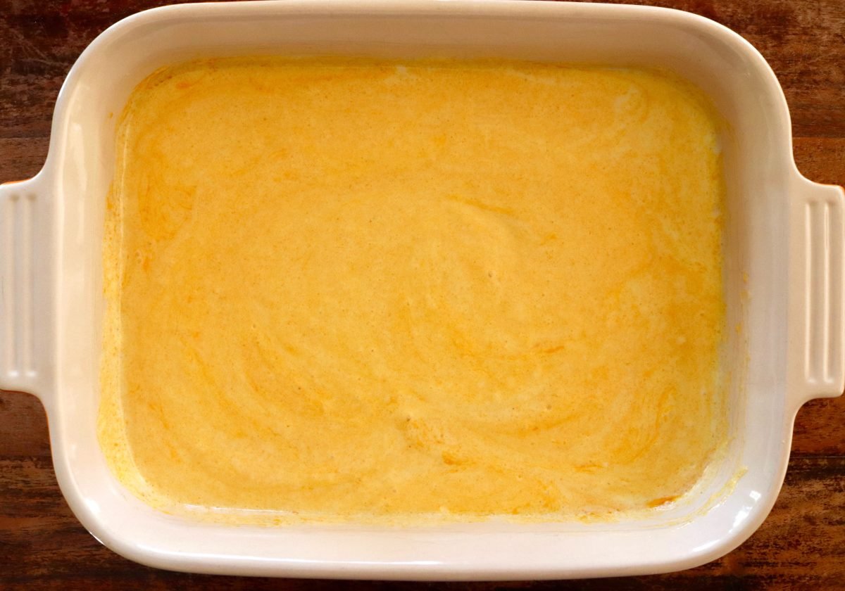 9 x 13-inch baking dish with thick and creamy mango sauce on the bottom.