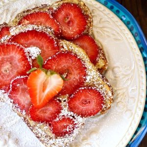 Two slices of Strawberry Frangipane Toast on white and blue plates.