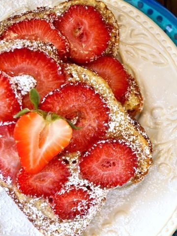 Two slices of Strawberry Frangipane Toast on white and blue plates.