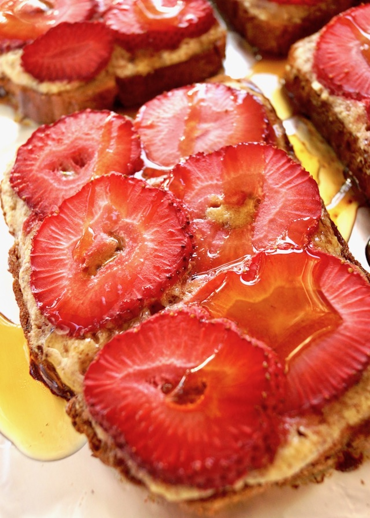 Strawberry-Frangipane-Toast-Recipe Close up of Strawberry Frangipane Toast with syrup drizzled over it.