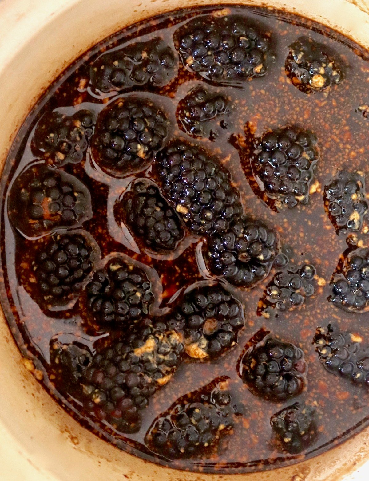 Small saucepan full with balsamic vinegar, blackberries and mustard.