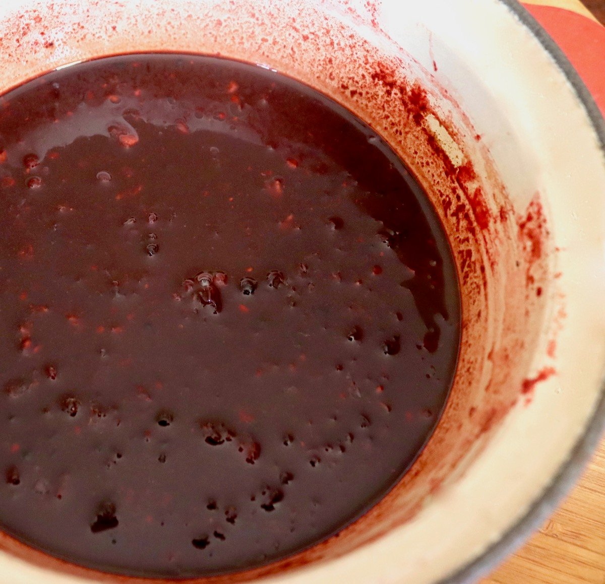 Smooth blackberry balsamic vinaigrette in a cream-colored saucepan.