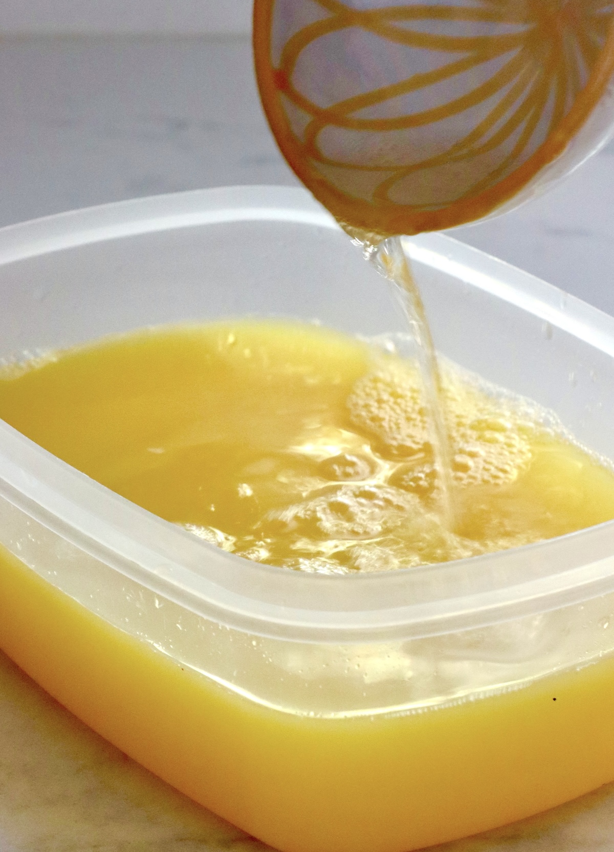 Frozen-Mimosa Champagne being poured into a plastic rectangular container.