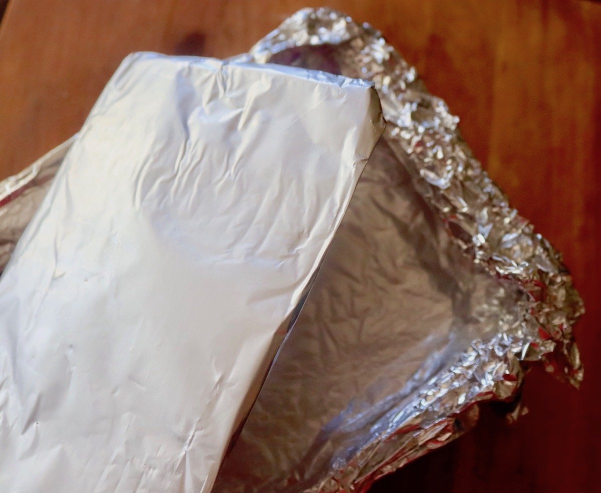 Foil wrapped cardboard to go on top of loaf pan to compress potato slices.