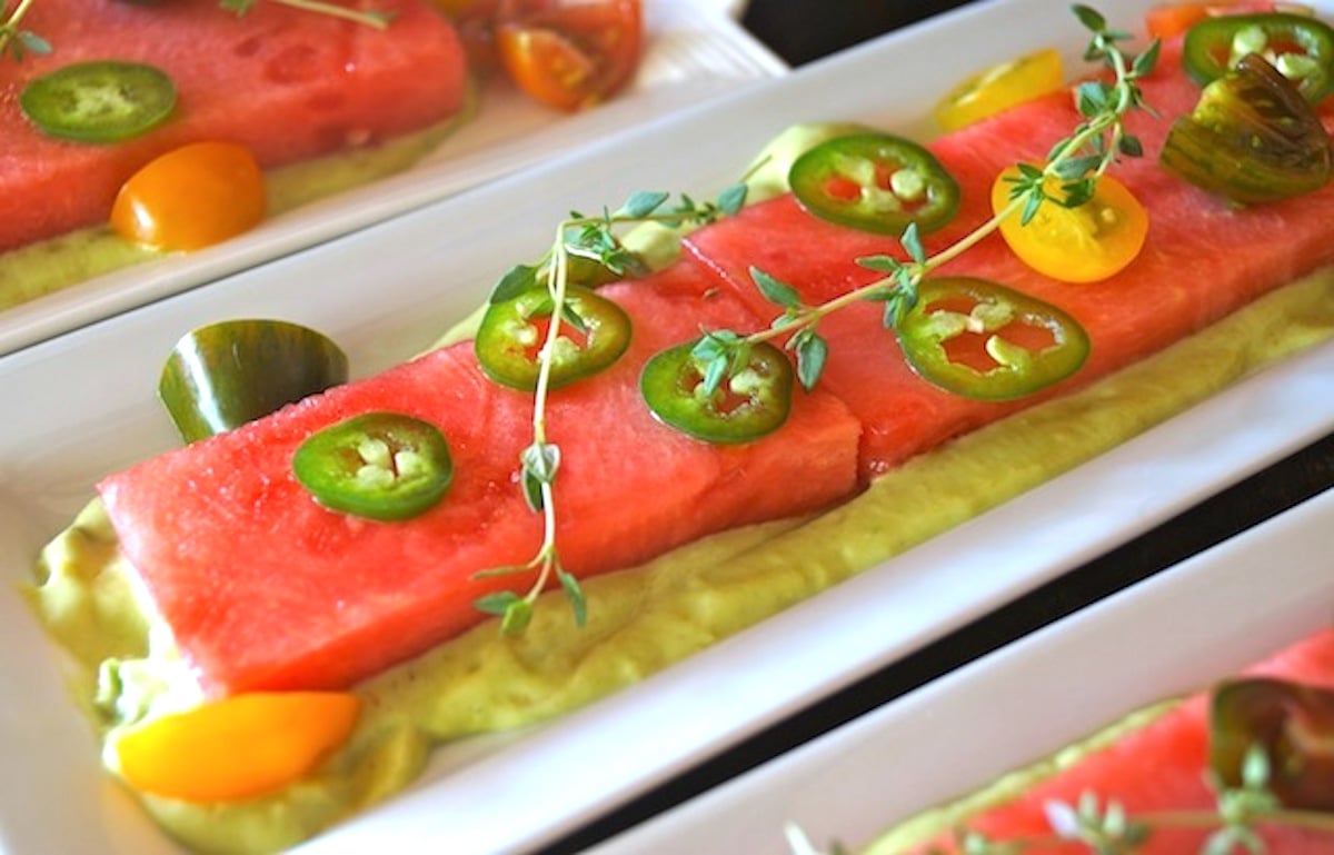 Compressed Watermelon Salad on a white plate with sliced jalapeno