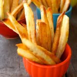 Small bright orange bowl holding French fries.