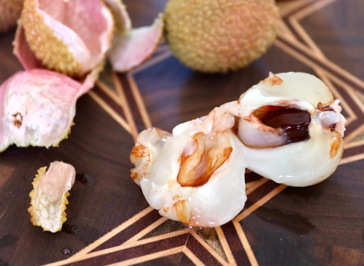 Lychee split in half with dark seed showing.