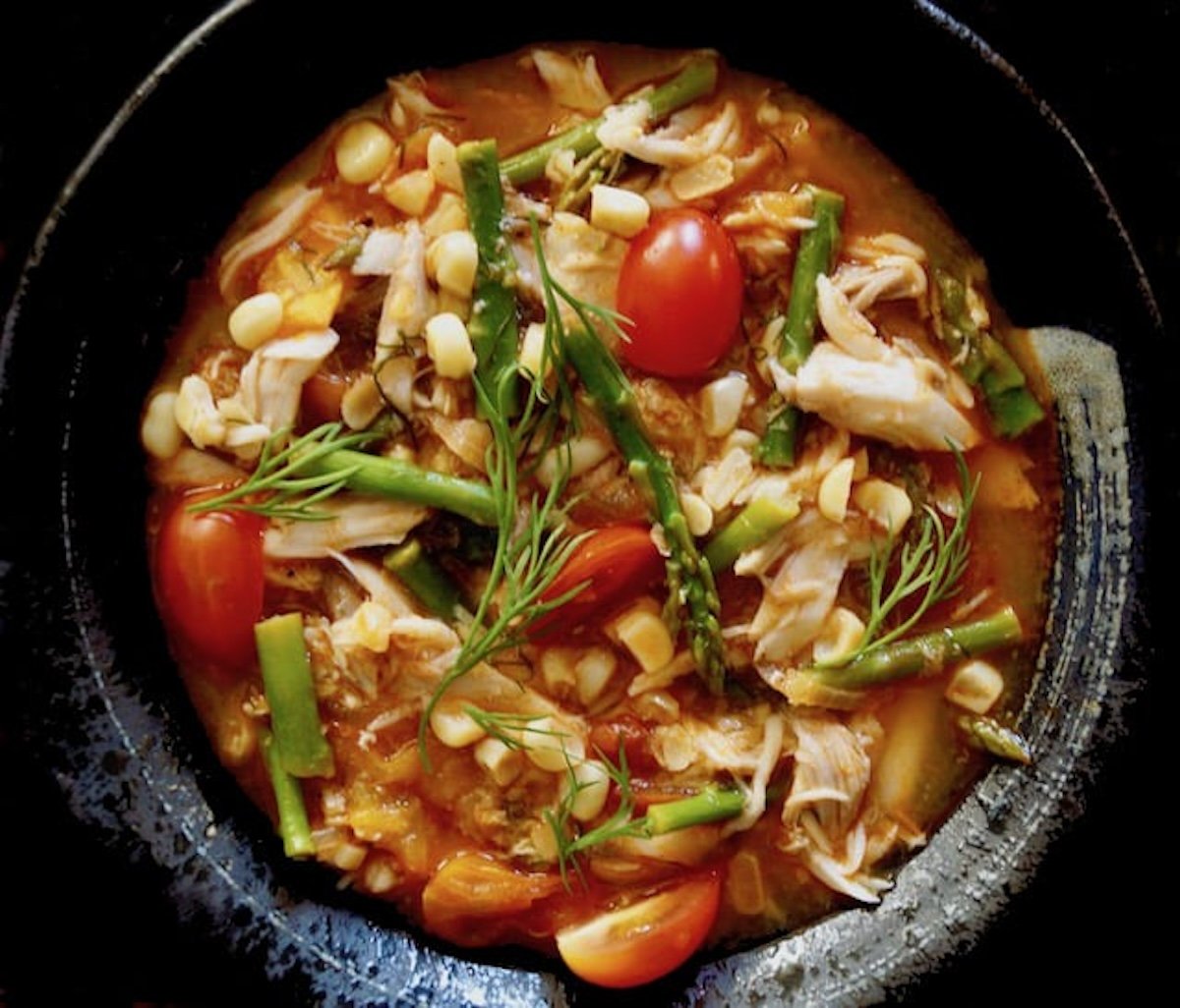 Close up of Summer Fish Stew in black bowl.
