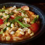 Close up of Summer Fish Stew in black bowl.