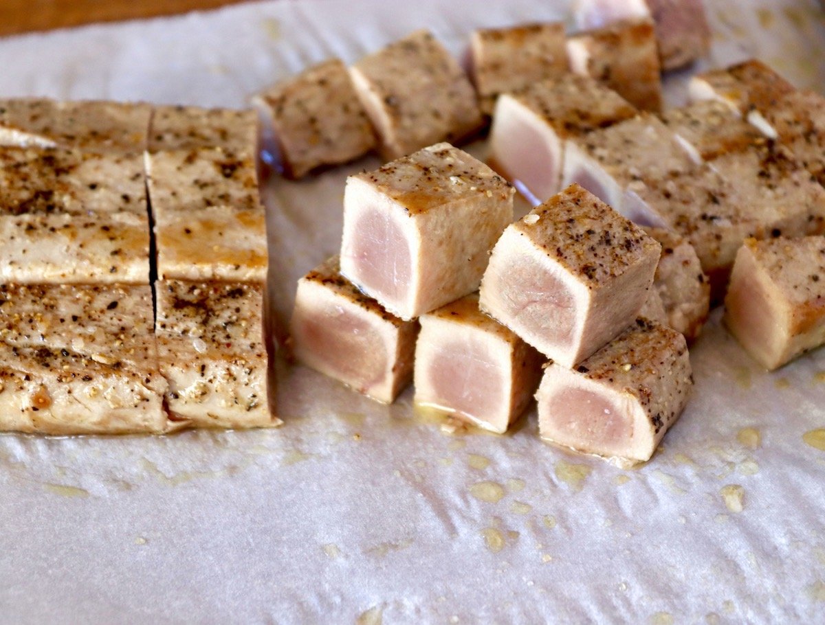 Several small cubes of seared ahi tuna on parchment paper.