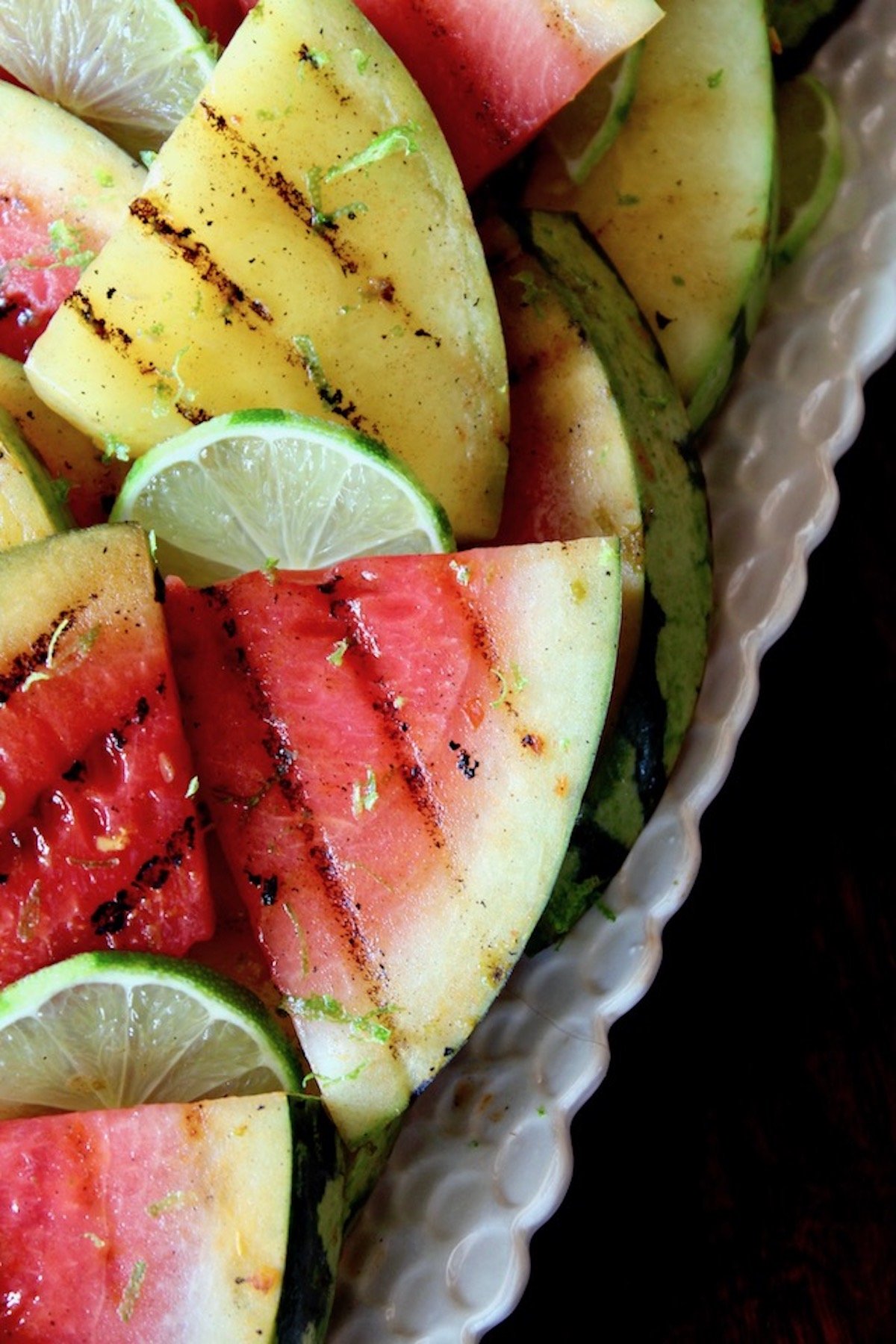 long white platter with red and yellow sliced, grilled watermelon