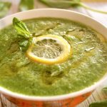 Cold Cucumber Soup with a slice of lemon in orange bowl with white rim