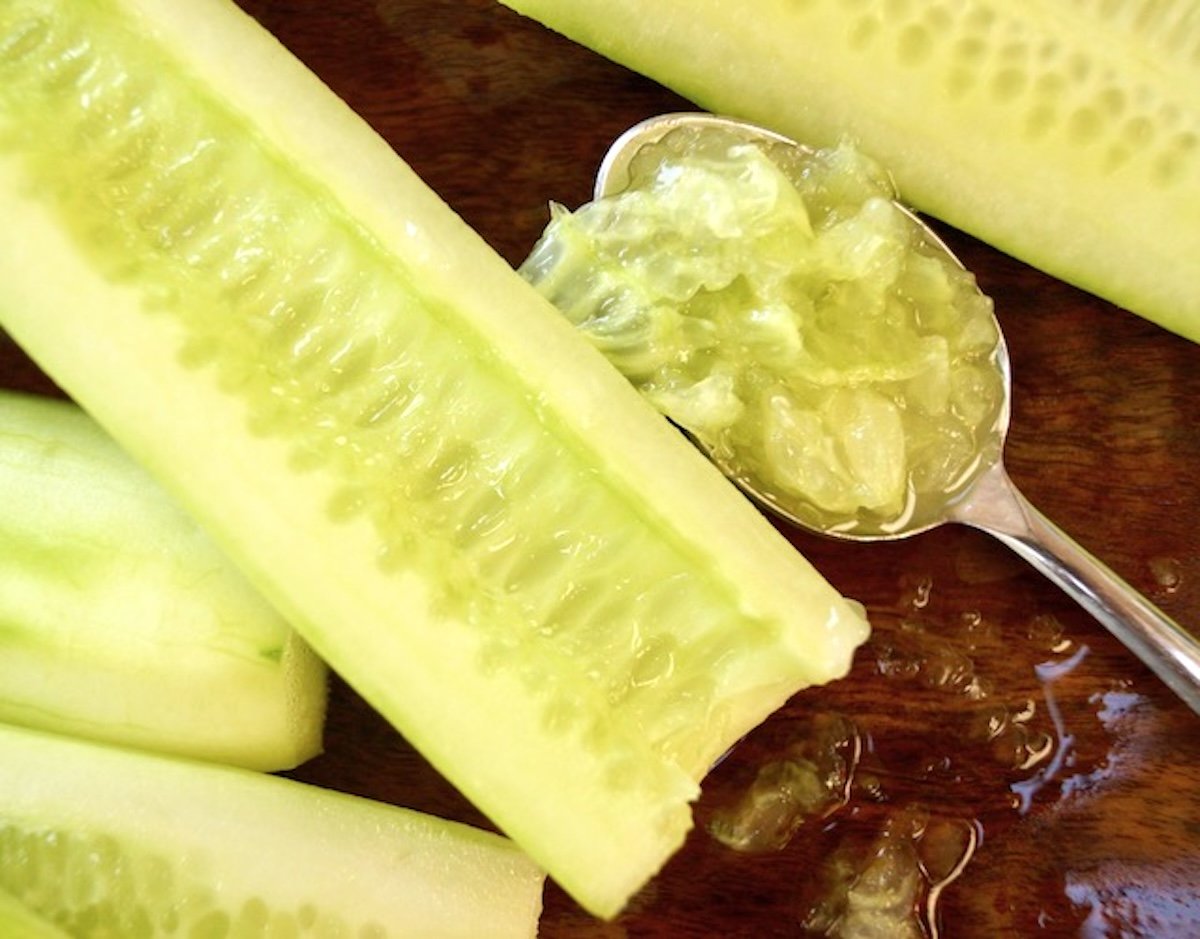 English cucumber with seeds removed and in a spoon next to it.