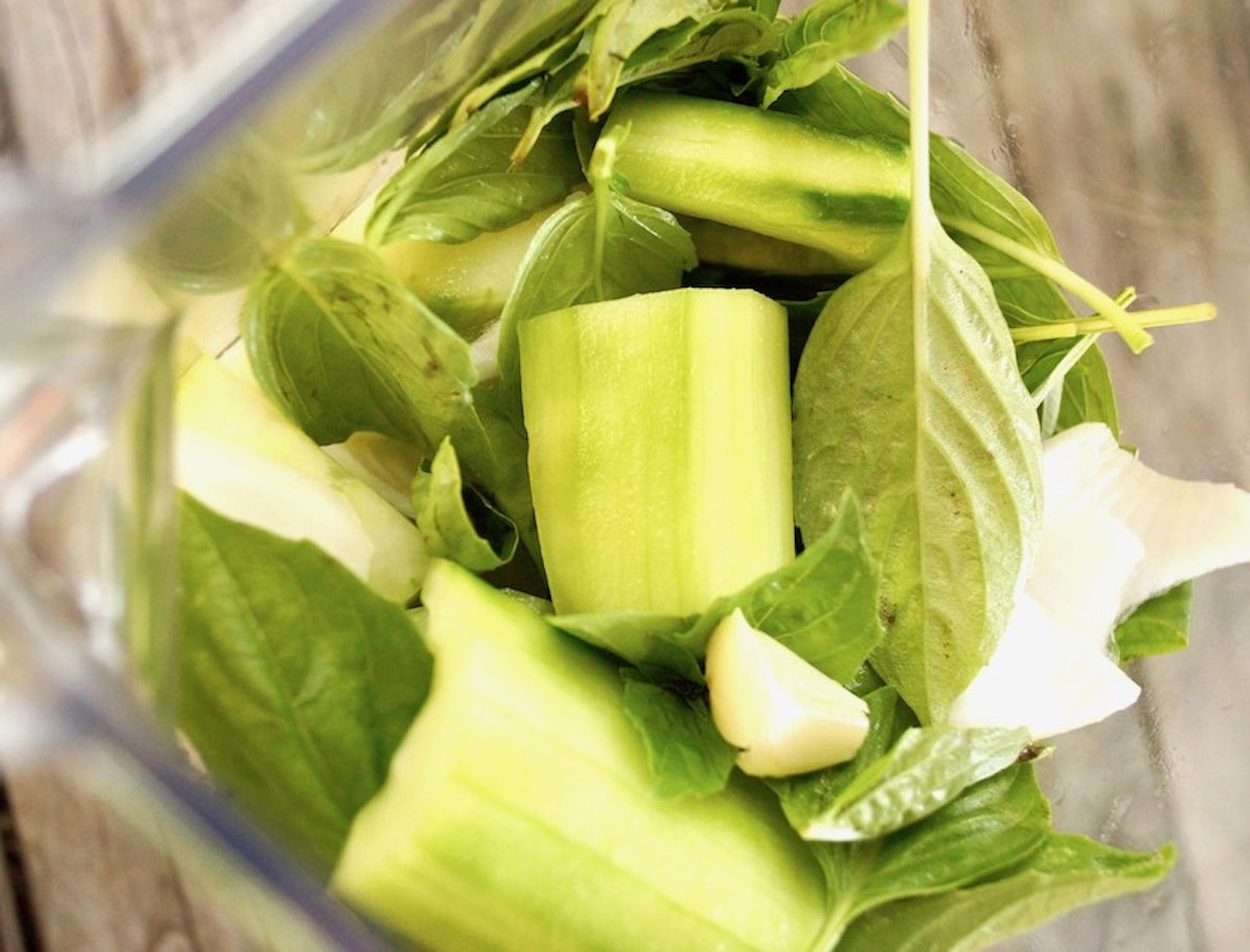 Cut cucumber, garlic and basil leaves in blender.
