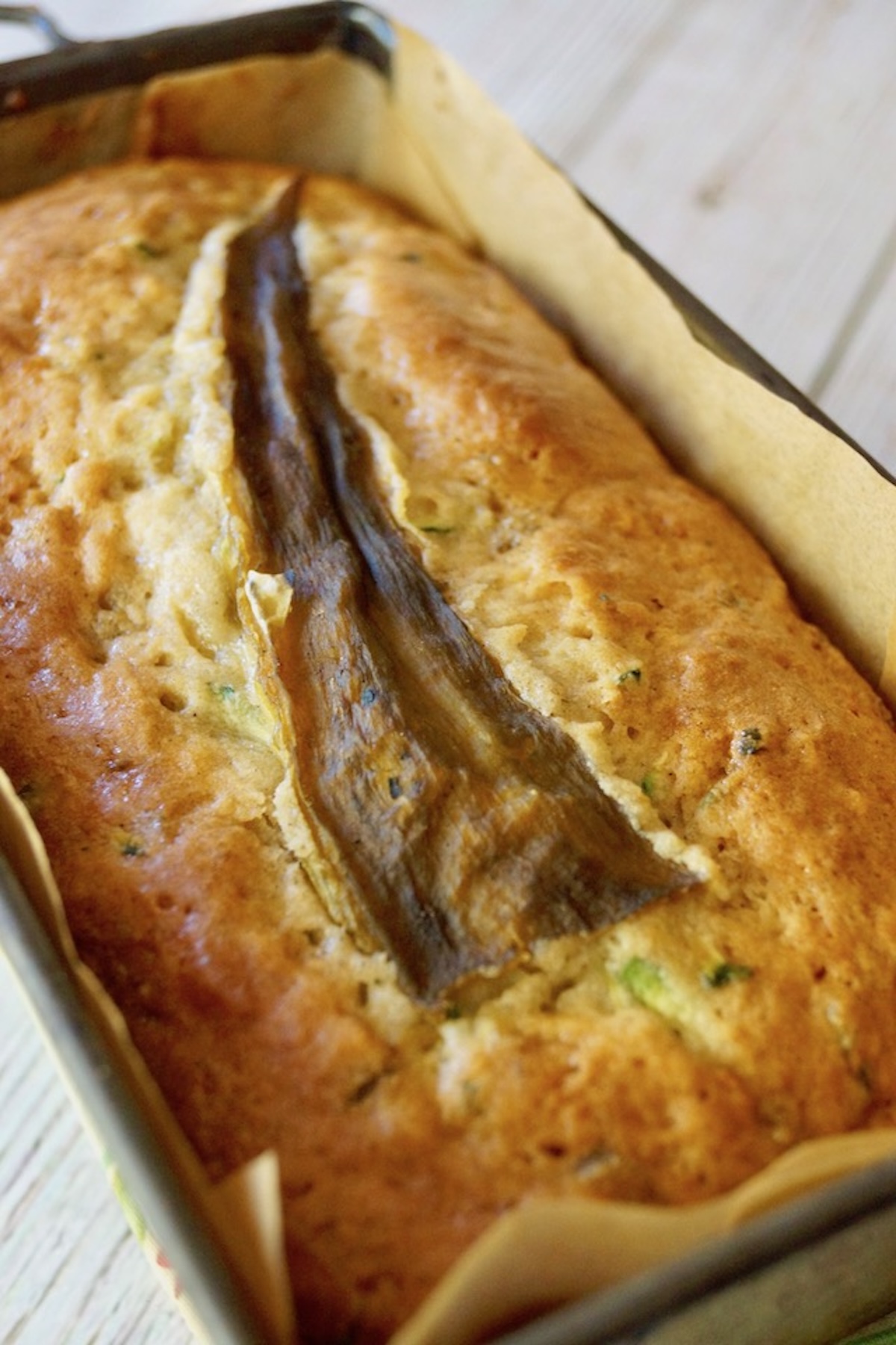 Baked loaf of gluten-free zucchini bread with a hatch chile pepper baked into the top.