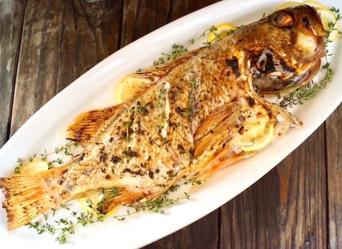 Whole Baked Vermilion Rockfish withlemon and thyme on white platter