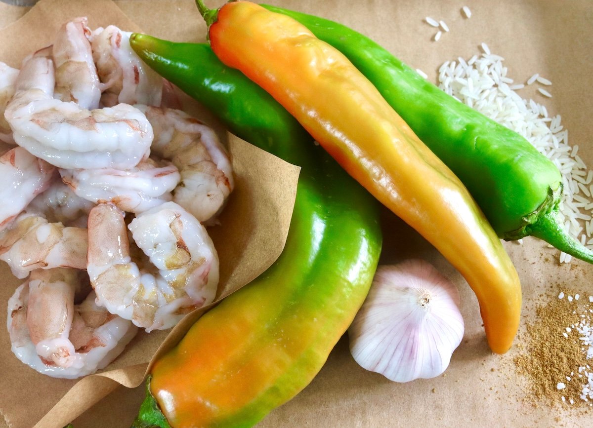 Ingredients for hatch chile shrimp including raw shrimp, garlic and fresh hatch chiles.