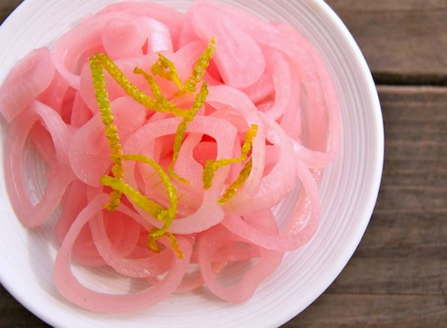 Pickled Shallots with lime zest on top on white plate