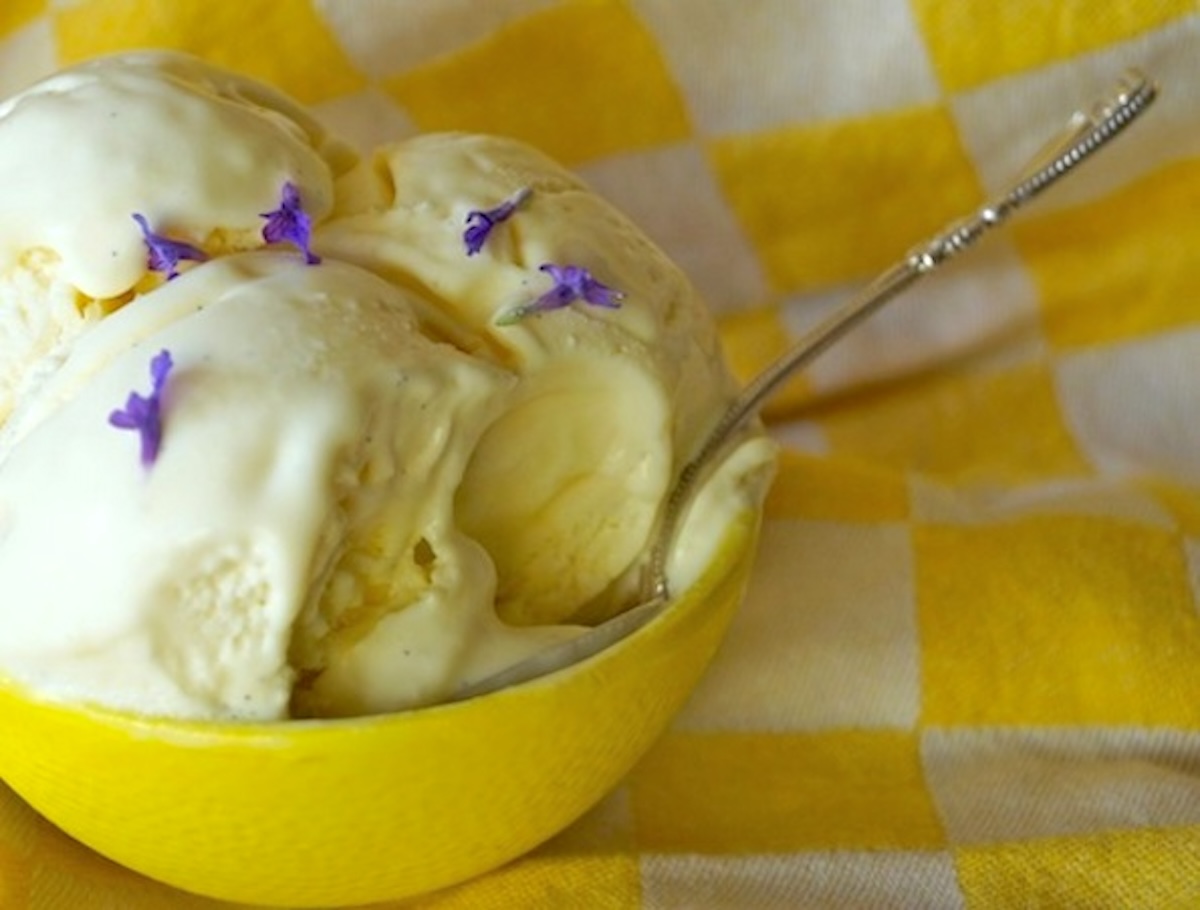 Lavender-Lemon-Frozen-Custard-Recipe Frozen lemon custard in a yellow bowl with a silver spopn and a bite or two removed.