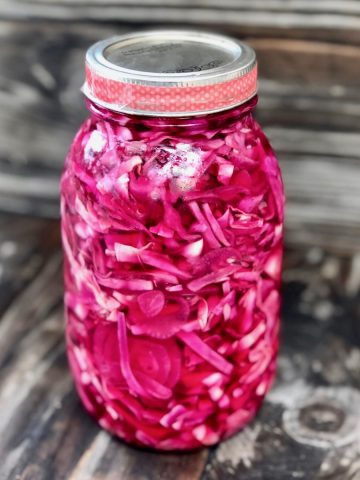 Magenta pickled cabbage in Mason jar with lid.