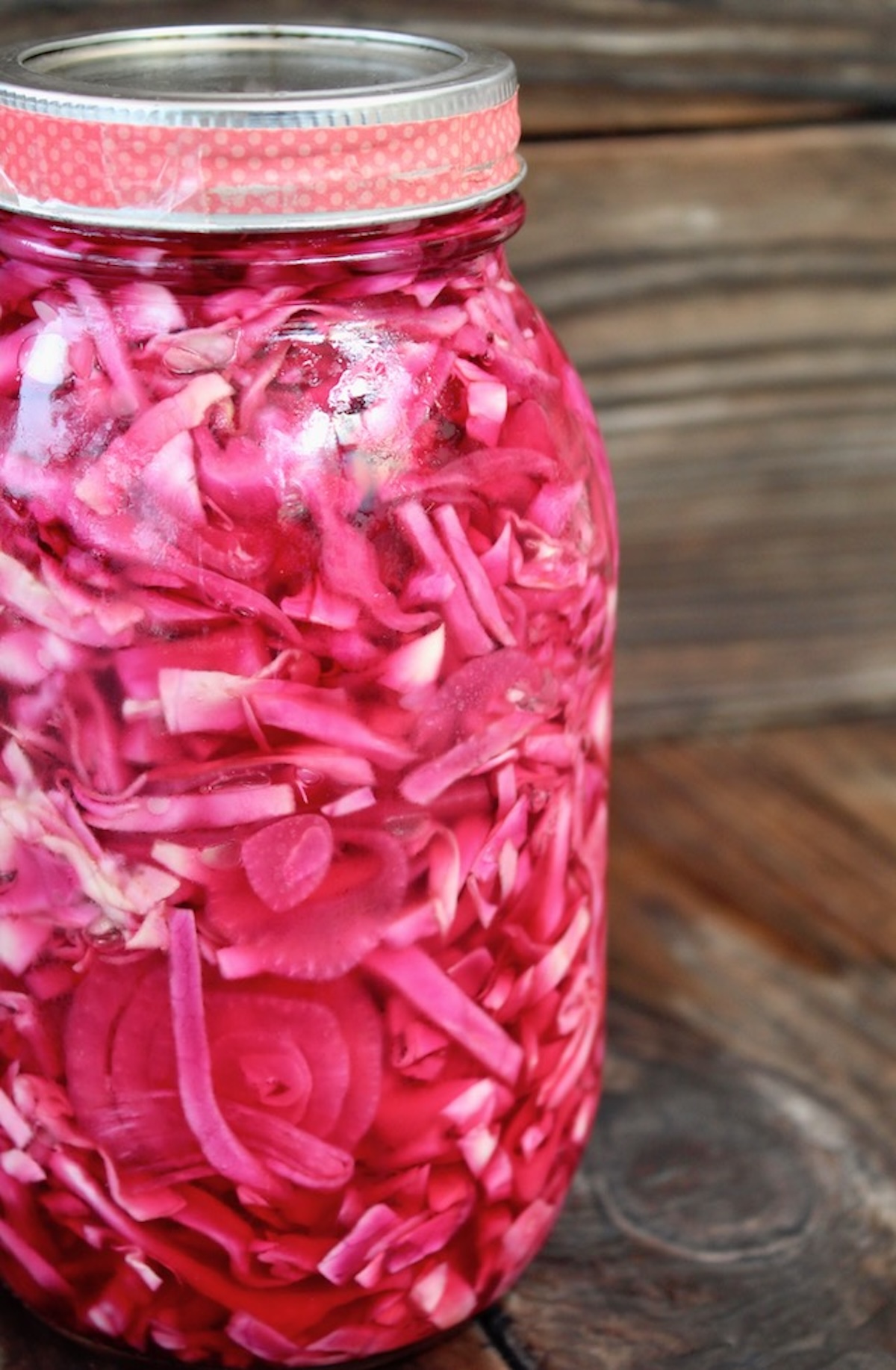 close up side view of Mason jar filled with red pickled cabbage.