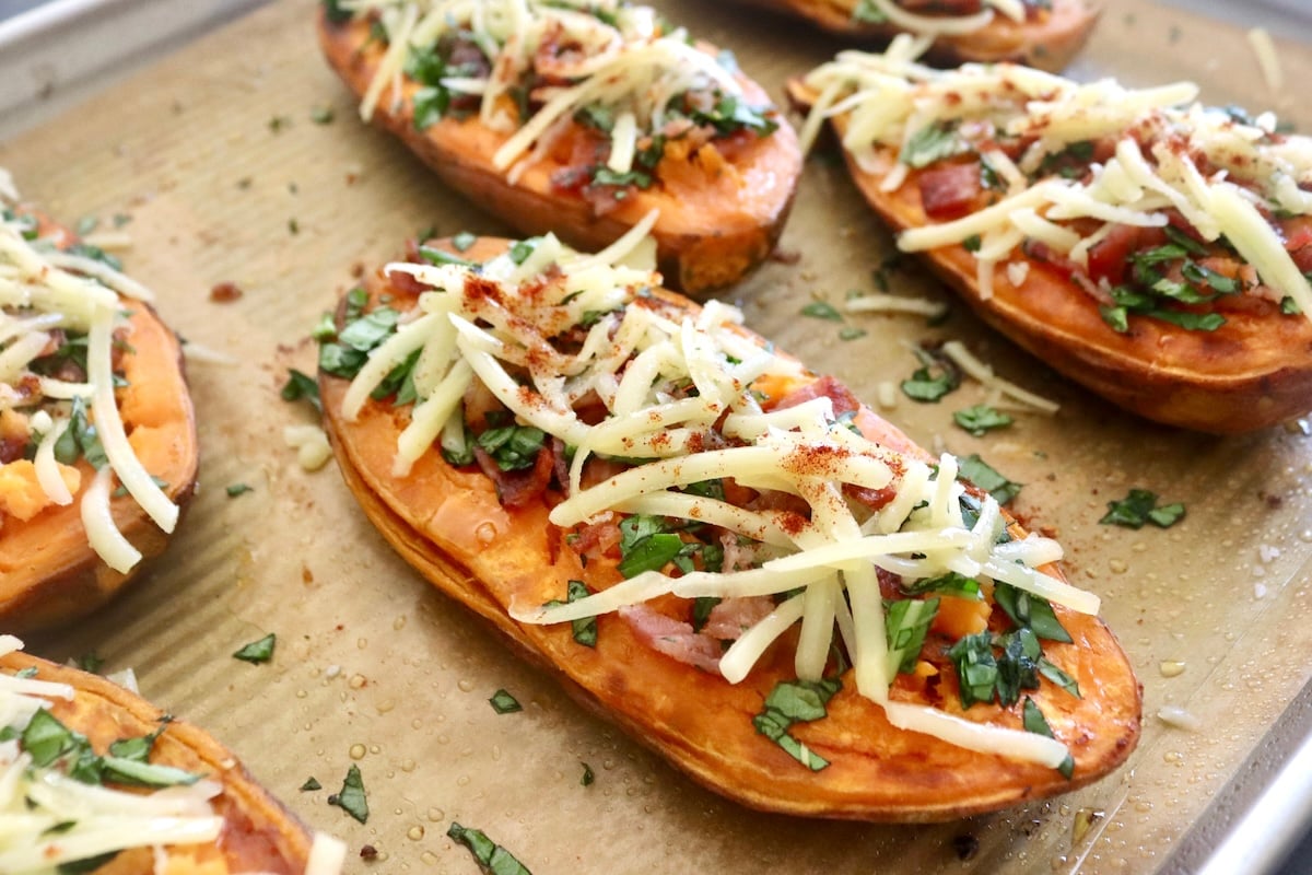 A few baked sweet potatoes halves with crumbled bacon, grated cheese and chopped basil on top.