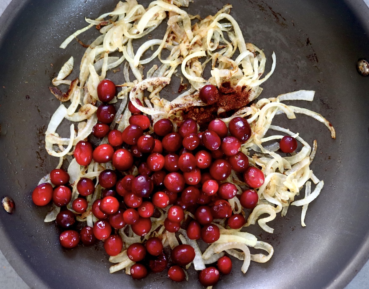 Caramelized onions and fresh cranberries in a skillet. 