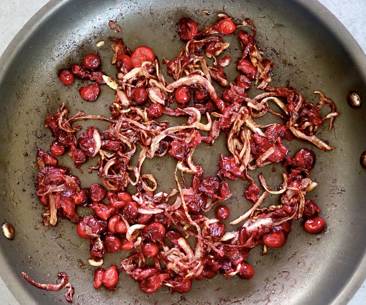Caramelized onions and cooked cranberries in a skillet. 