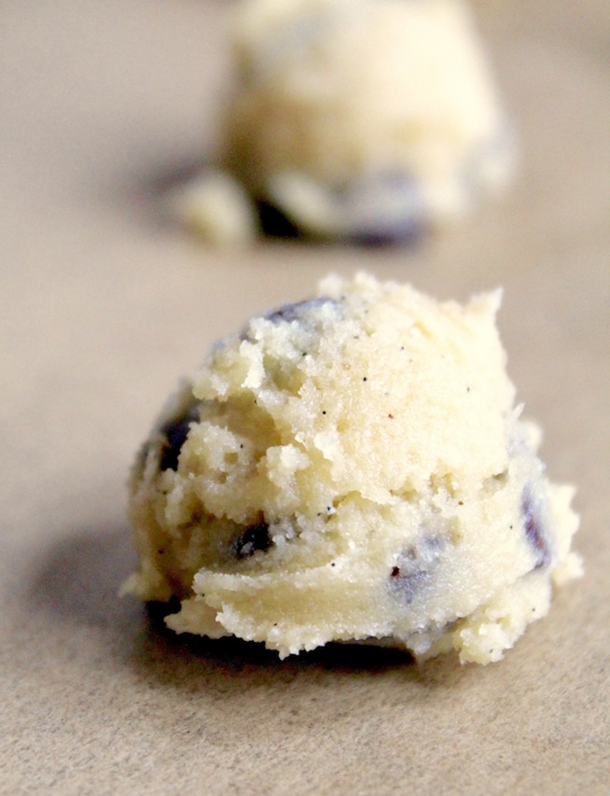 2 balls of coconut flour chocolate chip cookie dough on parchment.