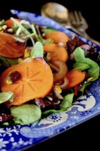close up of Persimmon salad on blue and white china platter