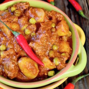 Green bowl with handles filled with Curried Beef Stew.