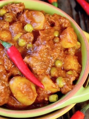 Green bowl with handles filled with Curried Beef Stew.