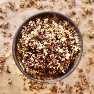 Top view of a brown-rimmed bowl filled iwth crisped quinoa.