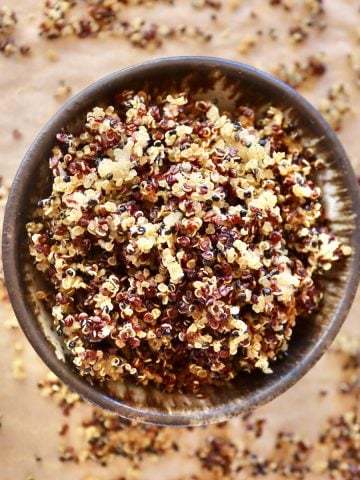 Top view of a brown-rimmed bowl filled iwth crisped quinoa.