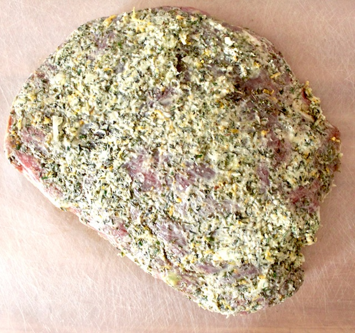 Mediterranean-Marinated-Flank-Steak Raw Flank steak with a think mariande with yogurt in it.