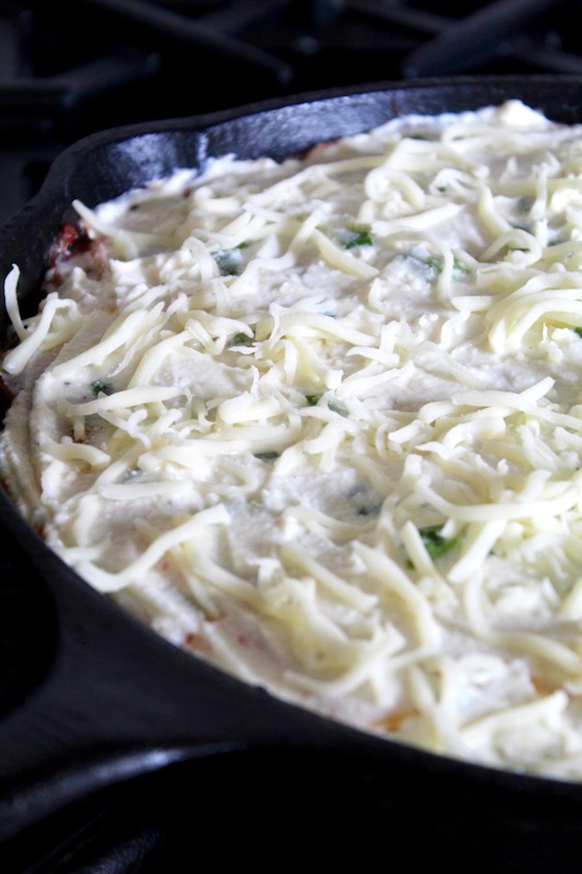 Root-Vegetable-Lasagna-with-Carrots Cast iron skillet with cheese-topped lasagna.