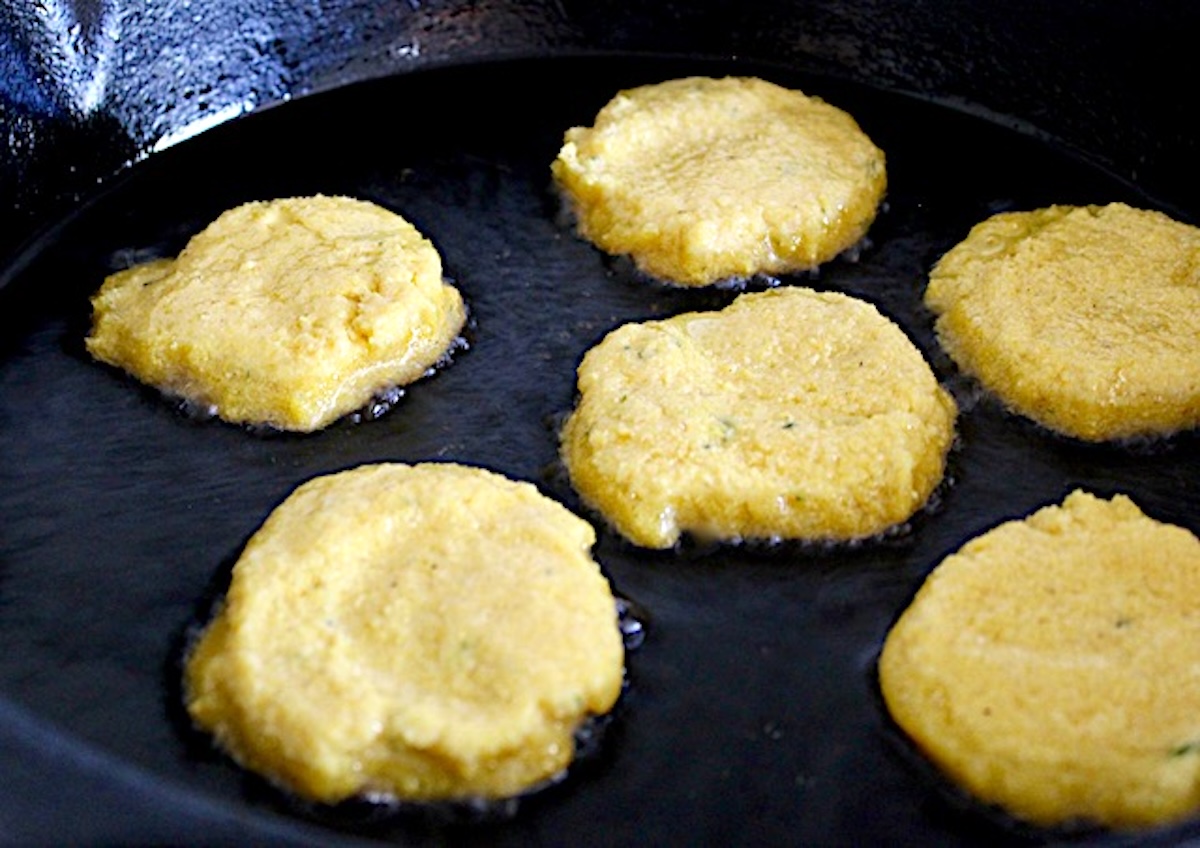 5 round hot water cornbreads in a skillet (looks like pancakes.)