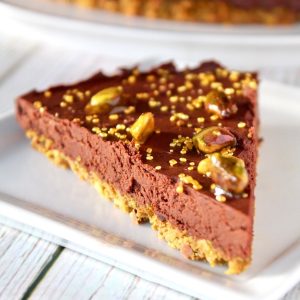 Slice of chocolate tart on a square white plate.