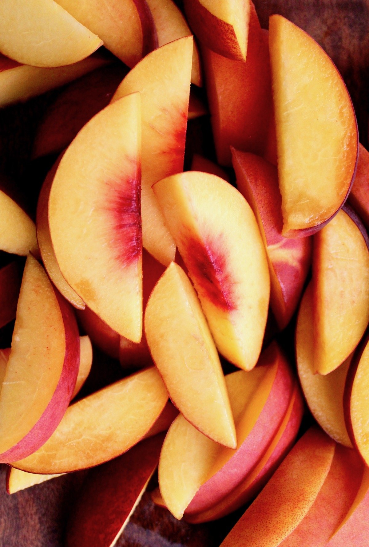 sliced peaches on a wooden cutting board