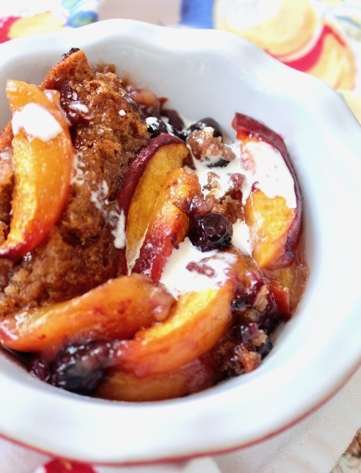 white bowl with peach cobber (gluten-free)