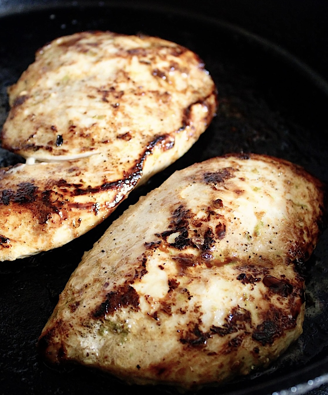 Tequila-Lime-Chicken Two cooked Tequila-Lime Chicken breasts in a cast iron skillet.