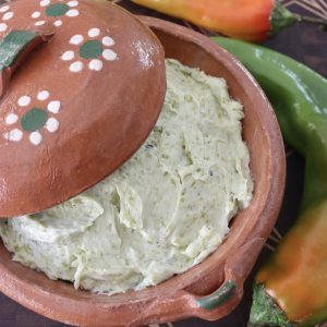 Close up of Hatch chile butter in a terra cotta bowl.