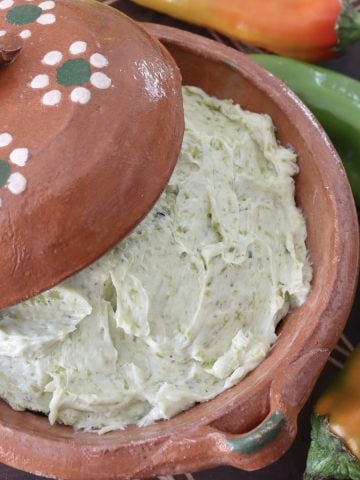 Close up of Hatch chile butter in a terra cotta bowl.