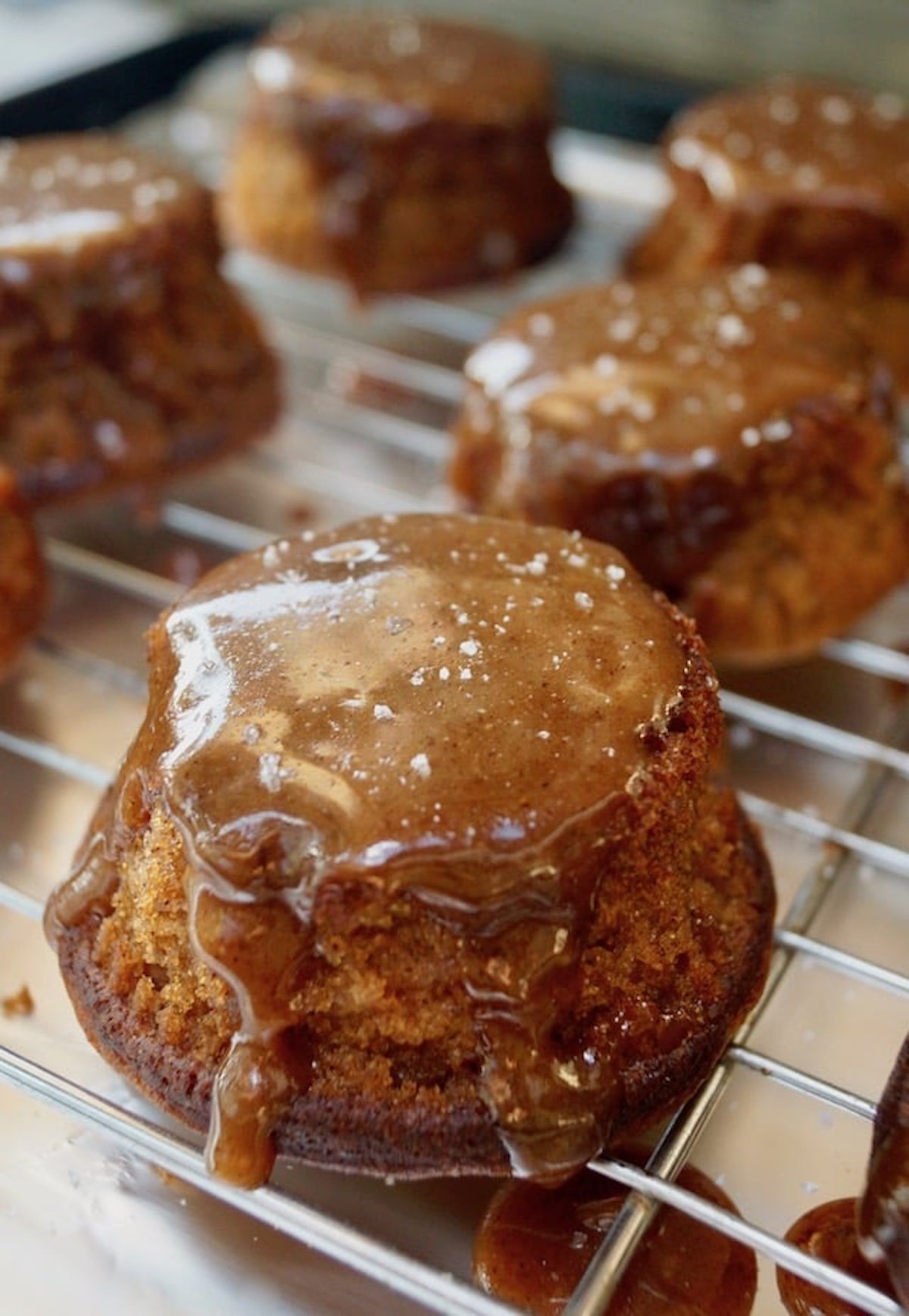 Caramel covered potato cakes on cooling rack.