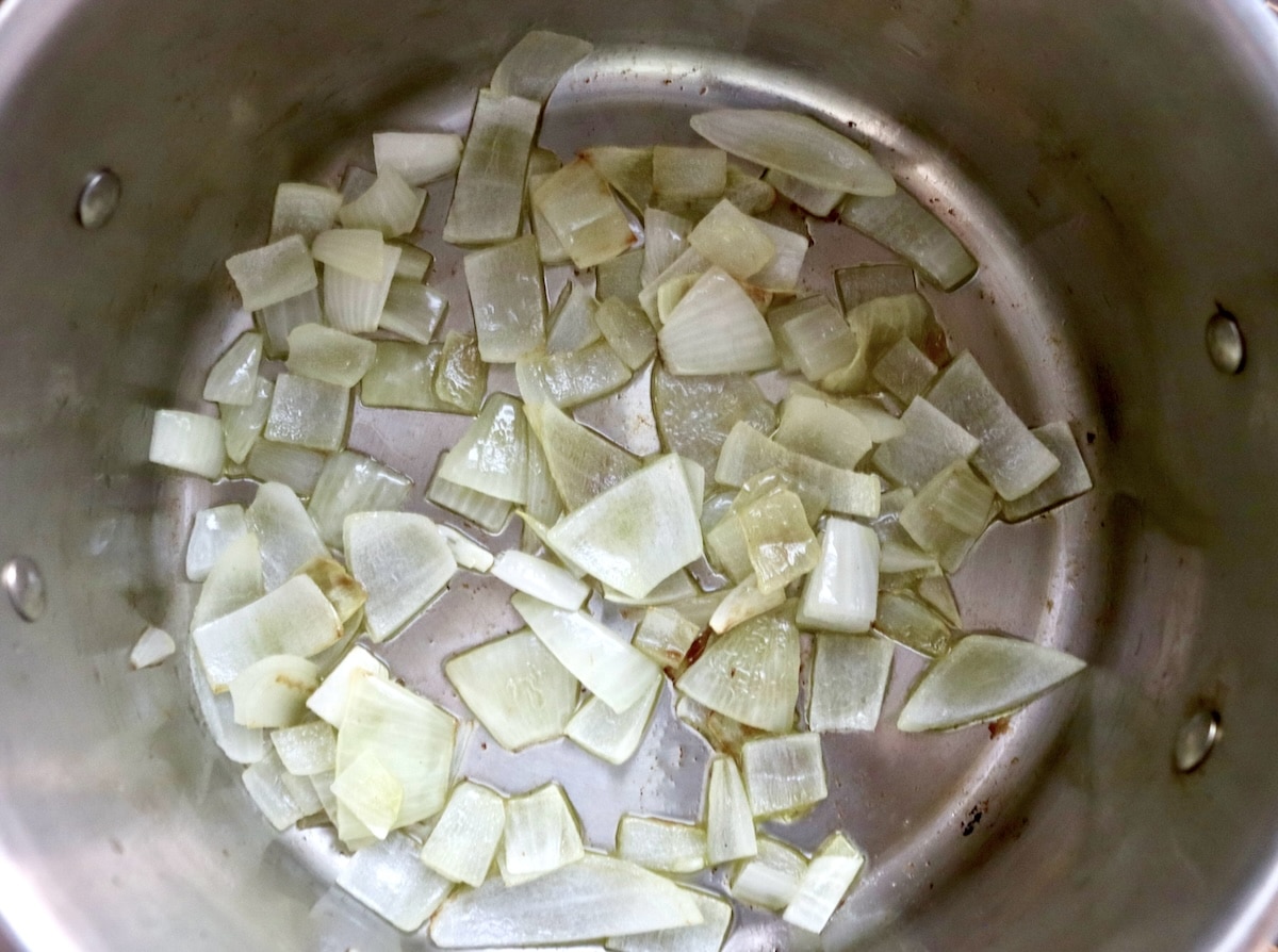 Coconut-Spiced-Carrot-Soup Softened and chopped onion at the bottom of a pot with olive oil.